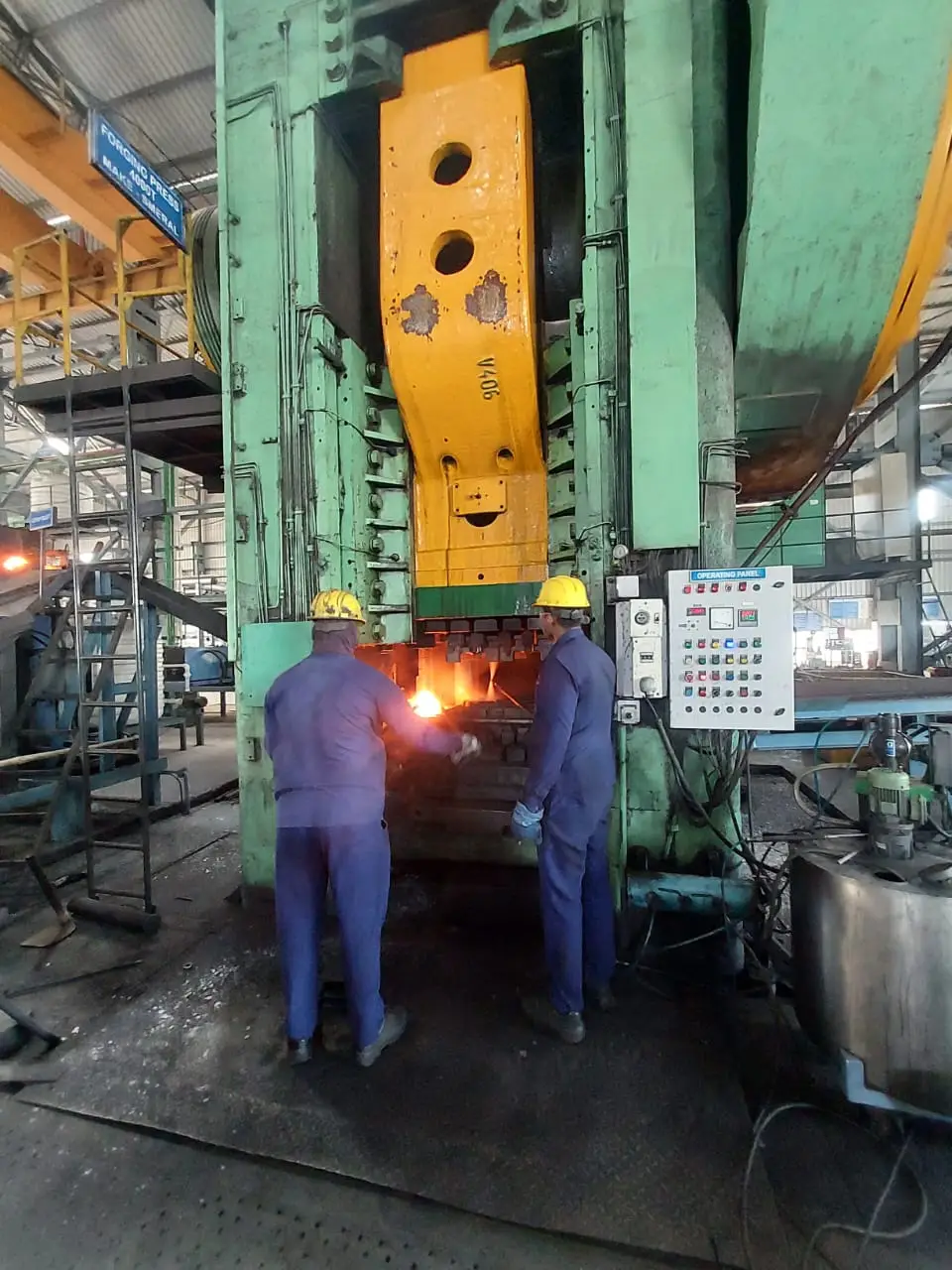 Two operators at the V406 closed die press at our Pune partner facility, the moment before a strike on a hot billet, walking the floor for the pre PO setup gate