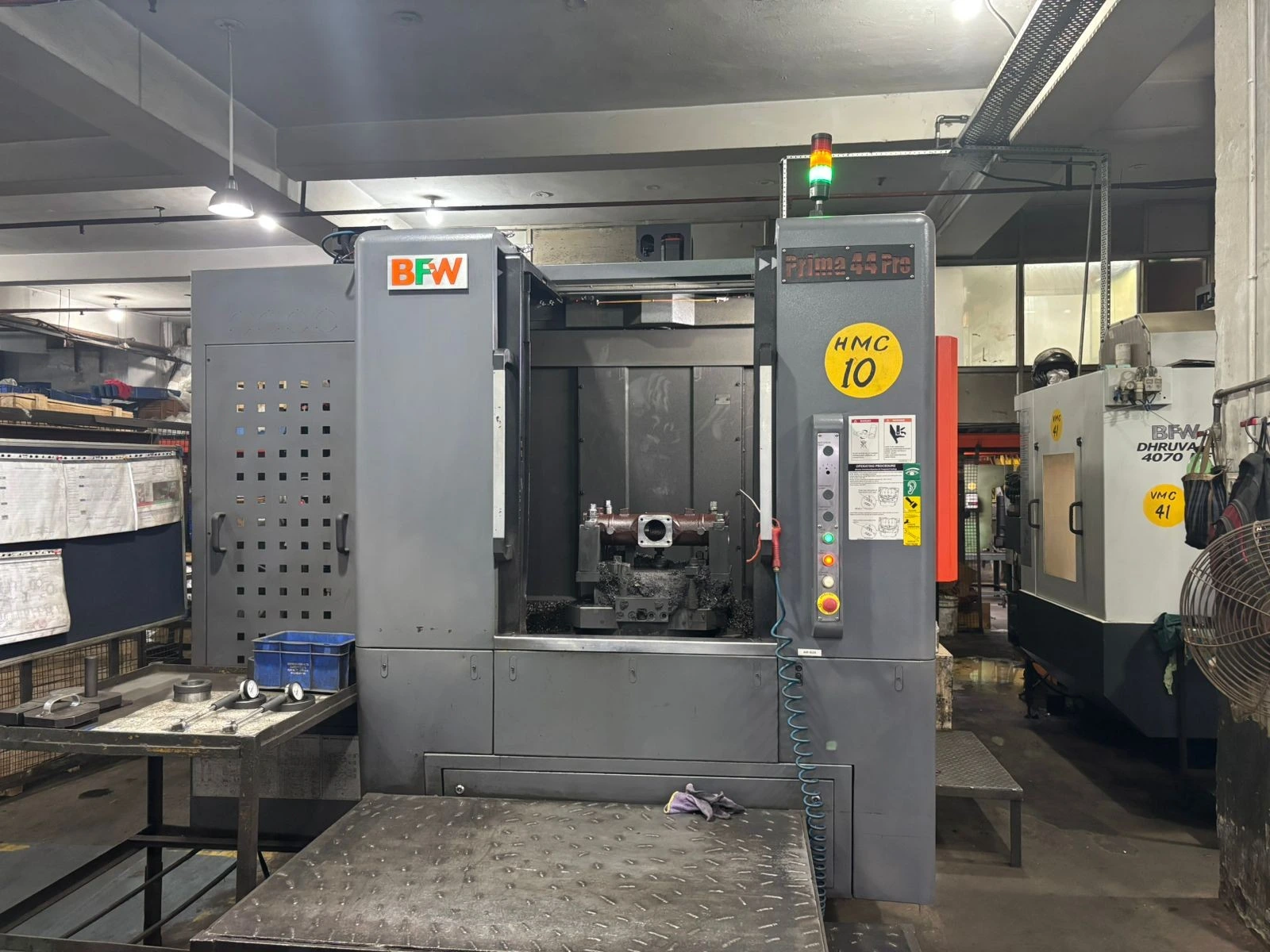 5-axis CNC machining center cutting a contoured titanium bracket in one setup at a VIA INDIGOS partner facility in India