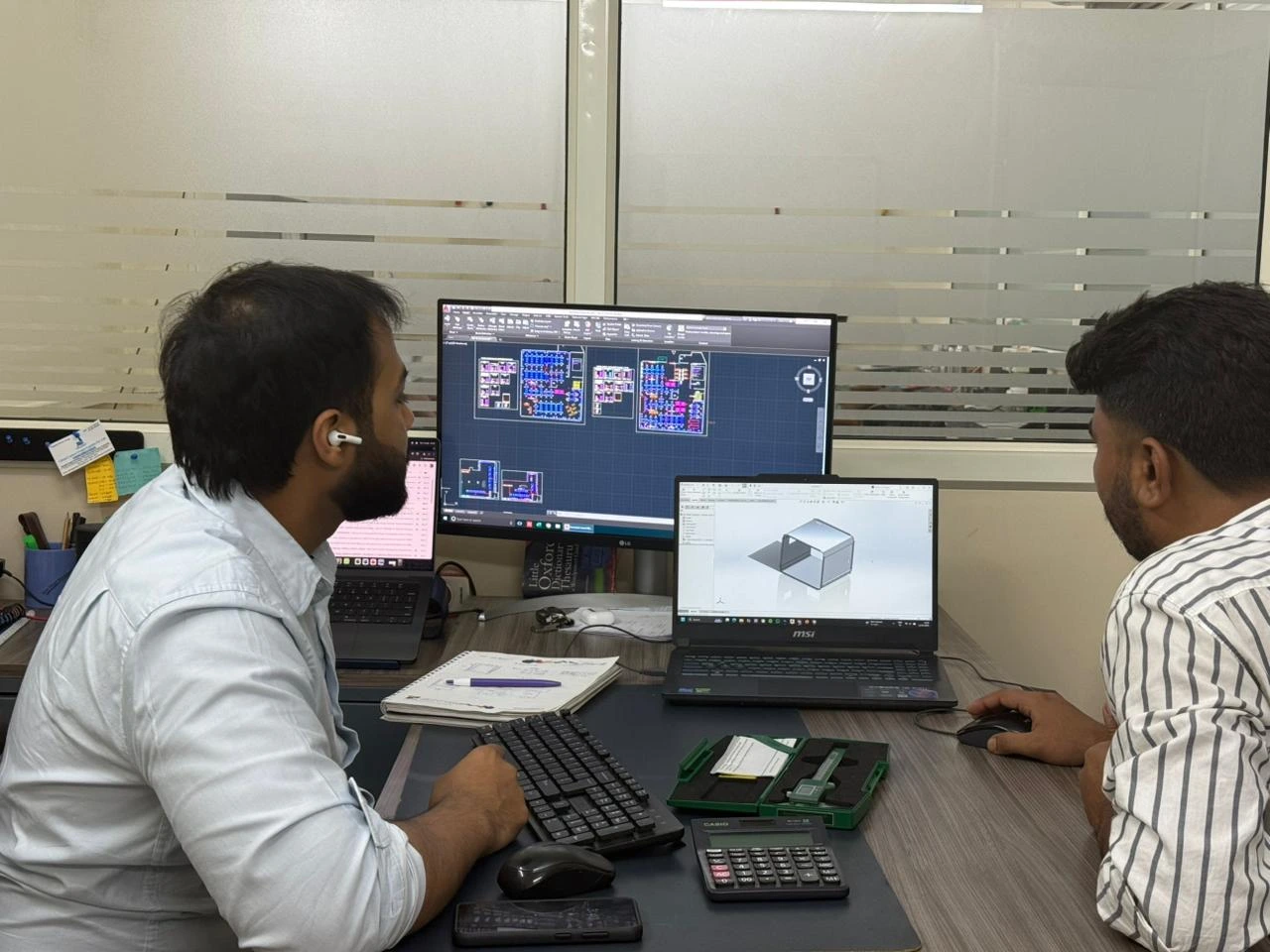 VIA INDIGOS team reviewing a CAD drawing and 3D part model for an India manufacturing quote