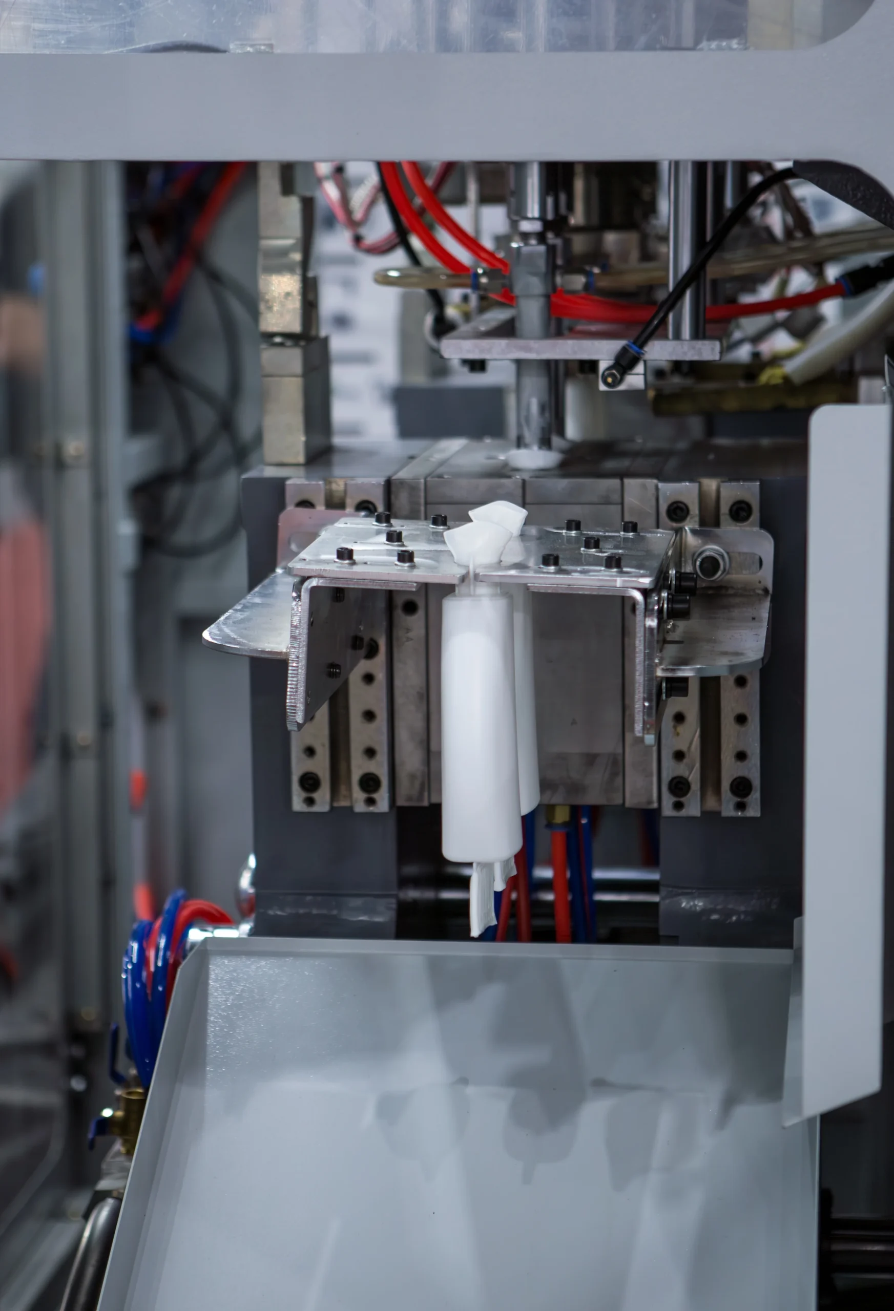 Injection blow molding machine and mold forming a small bottle at our India partner facility, where we walk the line before a single PO