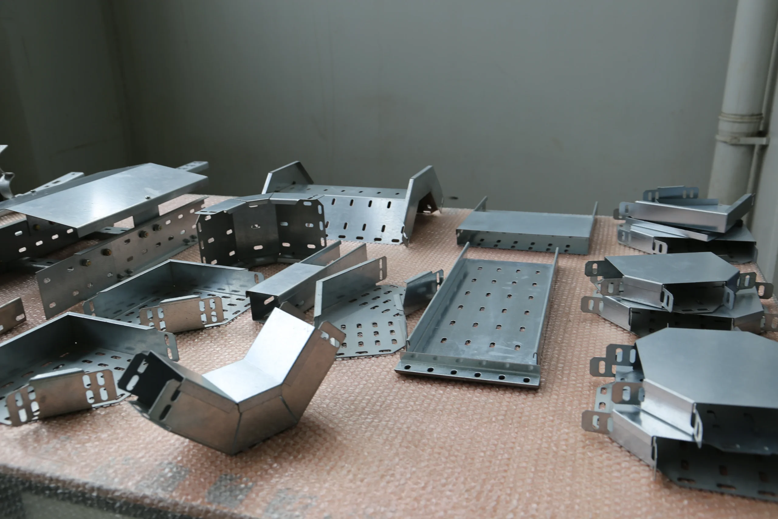 Rows of finished fabricated and welded steel brackets laid out at our India partner facility after the production run, batch volume in order