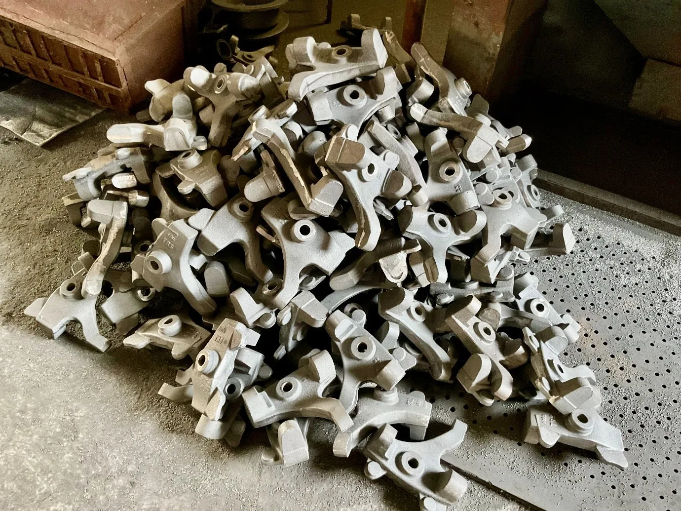 Batch of as-cast iron parts on the foundry floor at a VIA INDIGOS partner facility in India, photographed before fettling and shot blast as part of lot traceability documentation