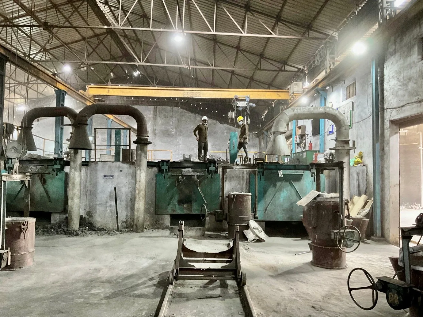 Induction melting furnaces on the melt deck of a VIA INDIGOS partner foundry in India, captured during a heat-sampling walkthrough
