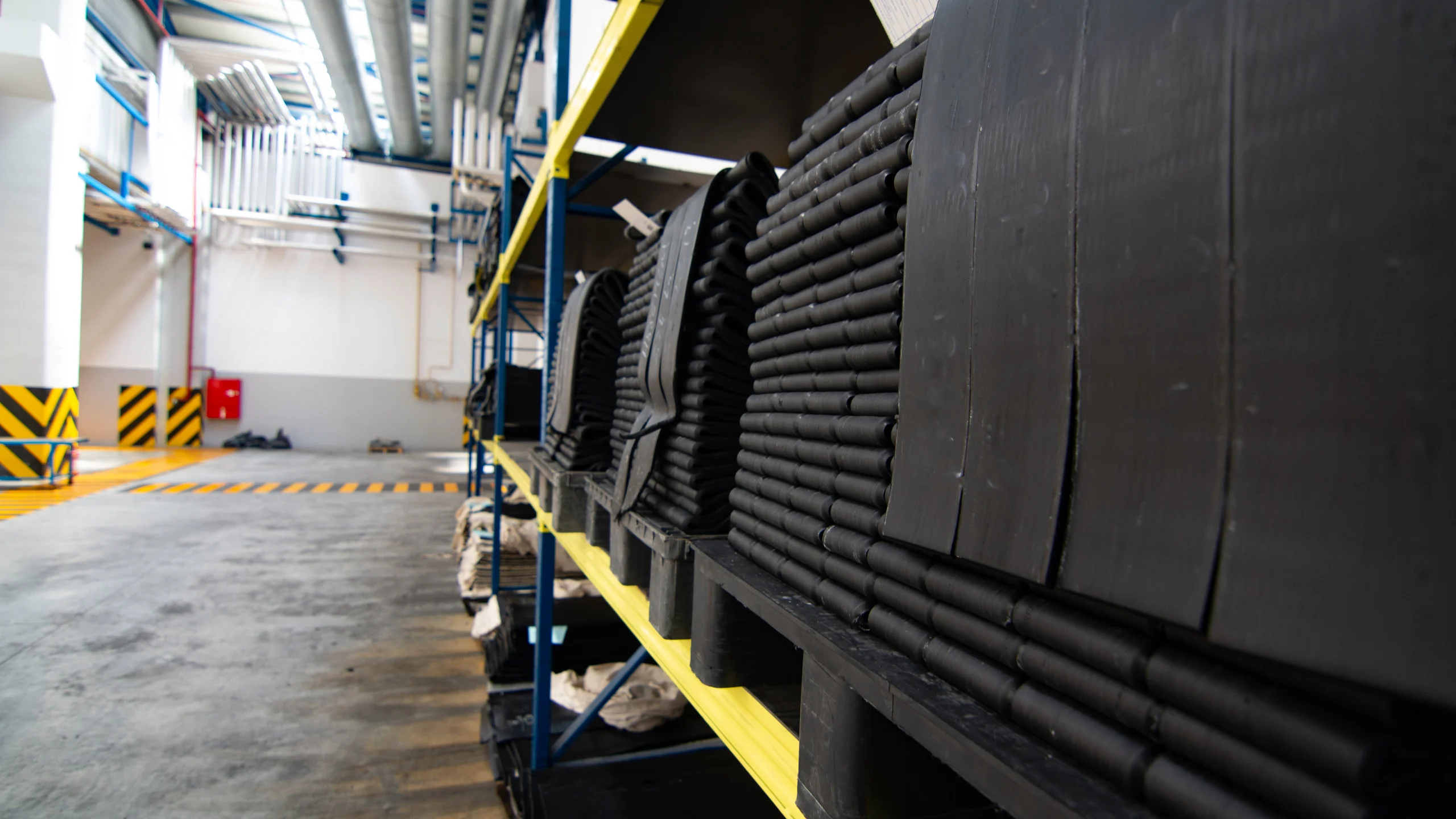 Extruded rubber profiles stacked on warehouse racks down a long aisle at our India partner facility, where we walk the line before a single PO