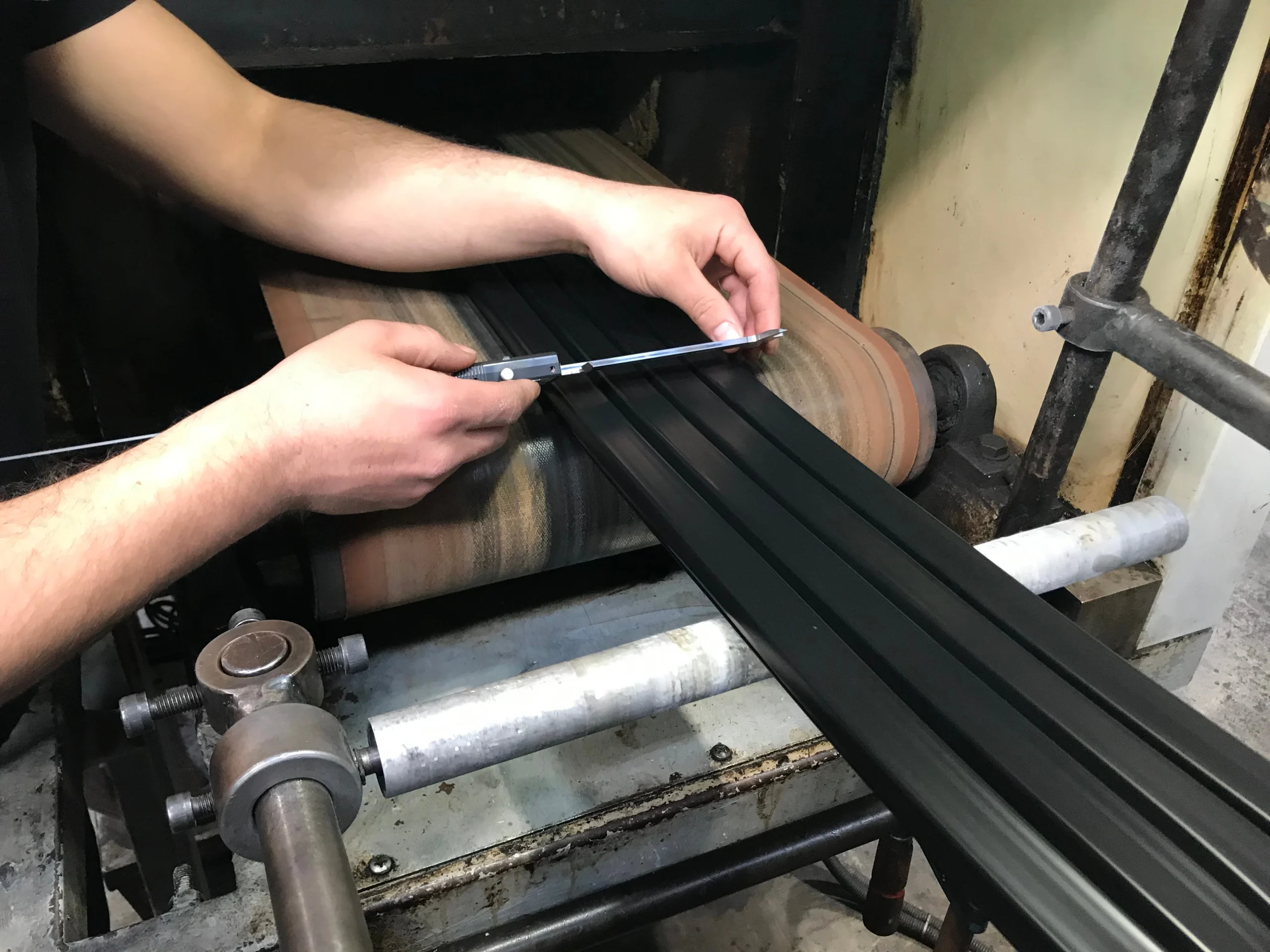 Operator gauging the cross section of an extruded rubber profile at the line at our India partner facility before the first PO