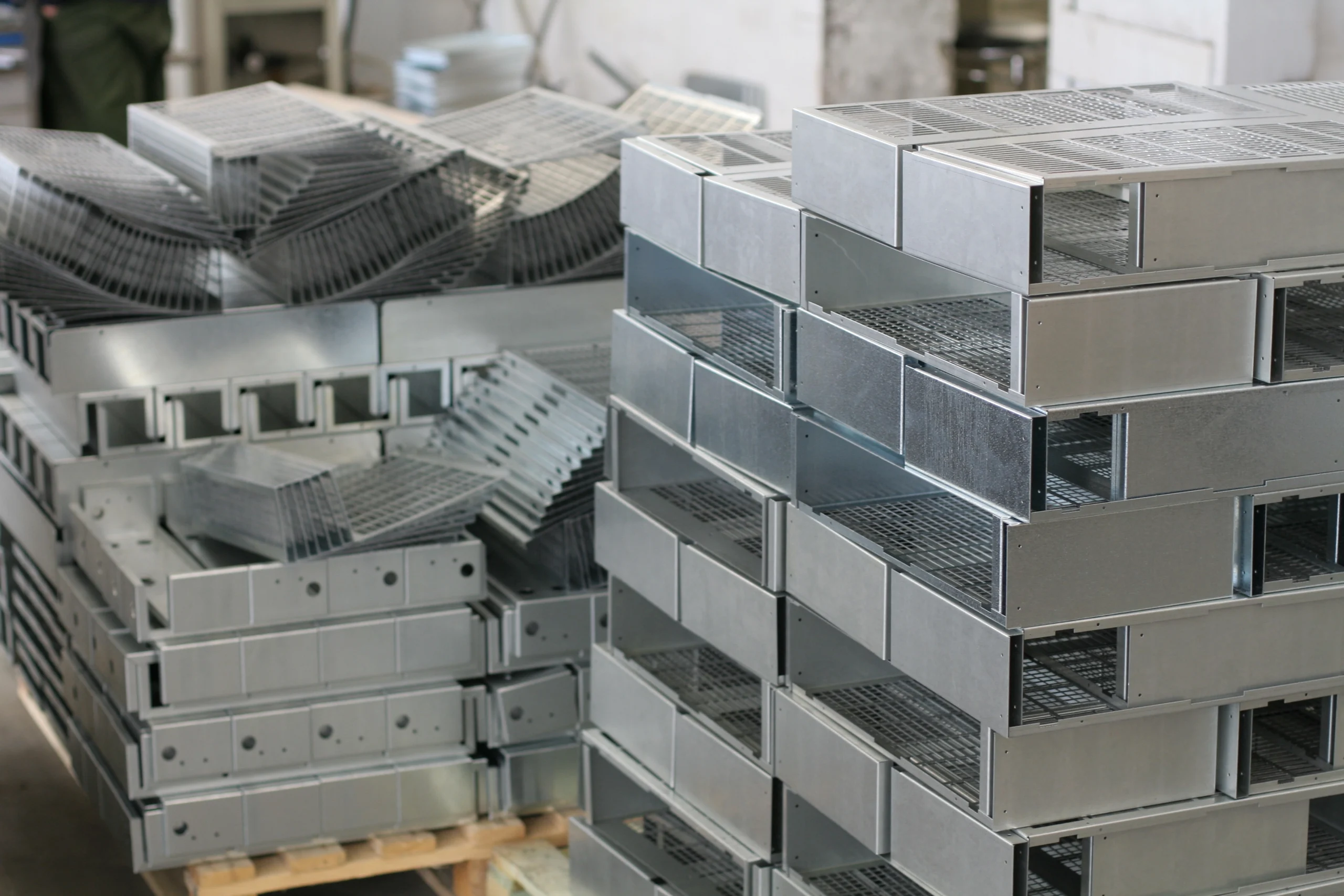Stacked fabricated steel sections ready to ship flat, where design for logistics cuts freight cost on sheet metal parts to your US dock