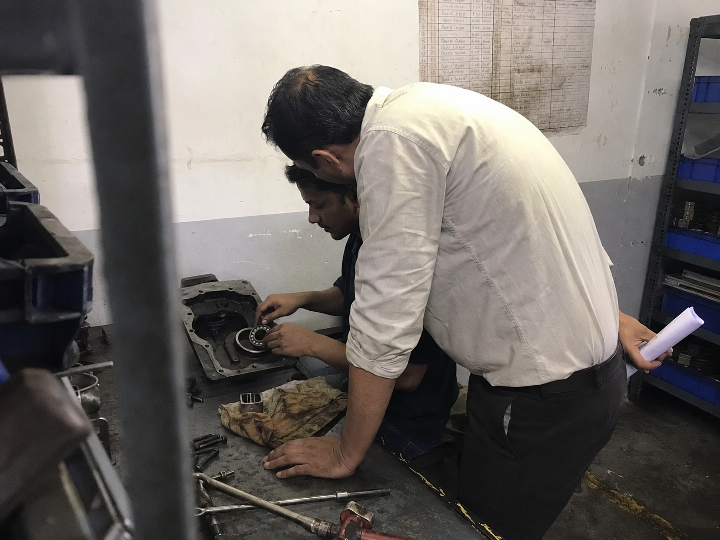 Our engineer watching a technician seat a bearing at the assembly bench during a facility visit in India
