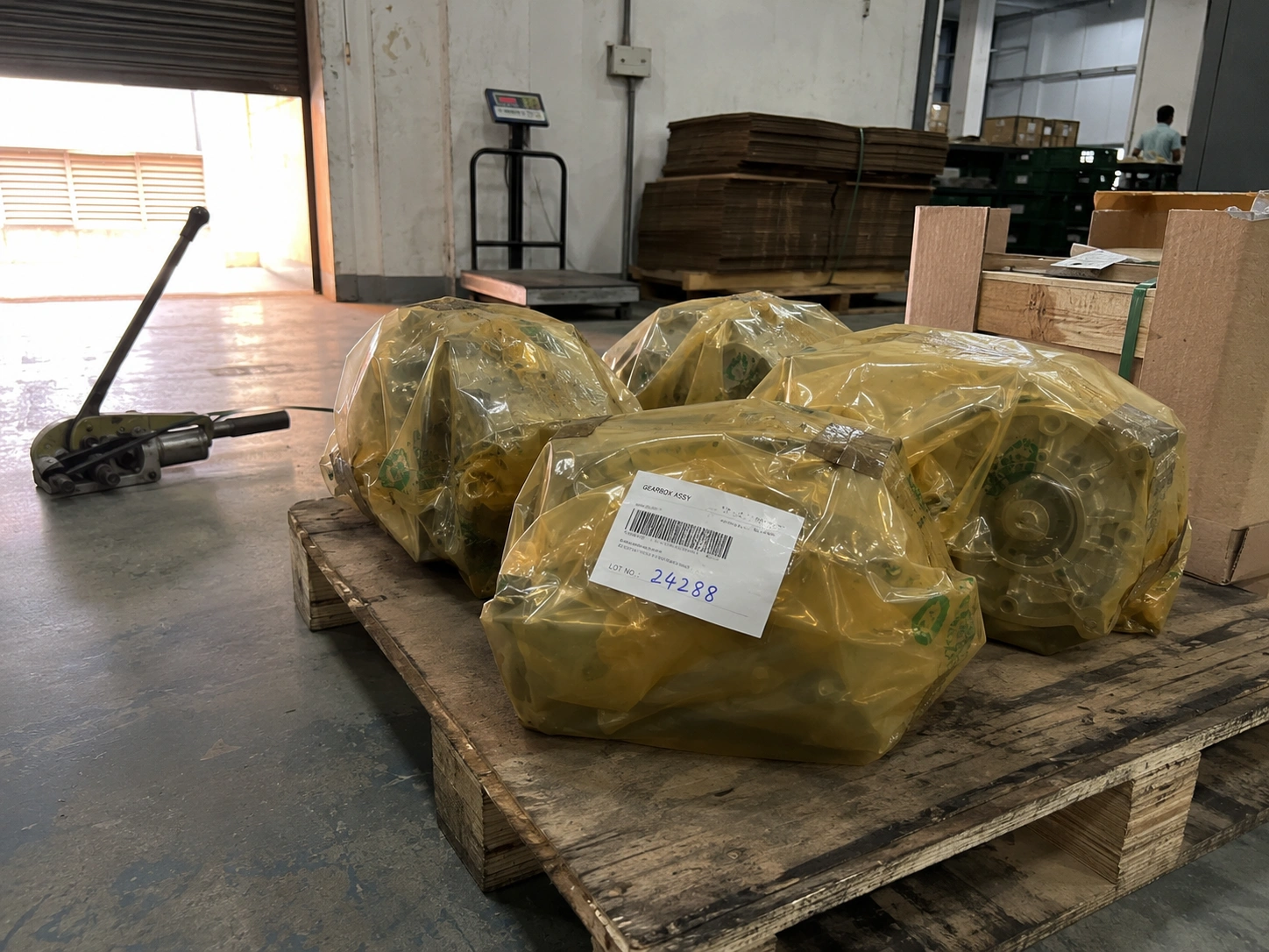 Completed gearbox assemblies wrapped in VCI paper with lot labels stacked on the dispatch pallet at our India partner facility